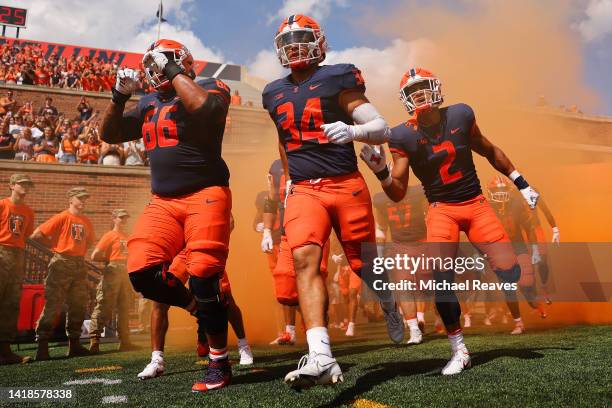 Jordyn Slaughter, Ryan Meed and Chase Brown of the Illinois Fighting Illini take the field prior to the game against the Wyoming Cowboys at Memorial...