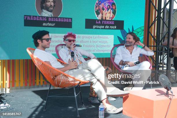 Sacha Got and Marlon Magnée of La Femme speak with Frédéric Beigbeder during Rock en Seine Festival on August 27, 2022 in Saint-Cloud, France.