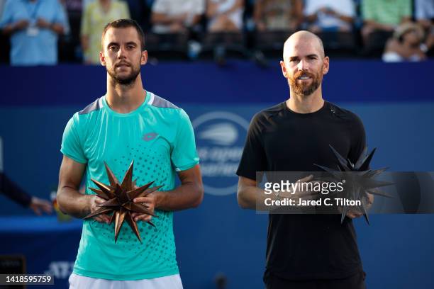 Champion Adrian Mannarino of France poses with finalist Laslo Djere of Serbia following the men's singles championship final on day eight of the...