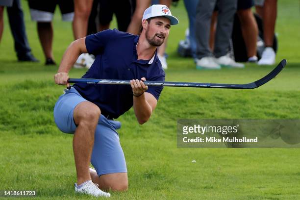 Detroit Red Wings forward Dylan Larkin hits a golf shot with a hockey puck on the 17th hole during a celebrity shootout after the second round of The...