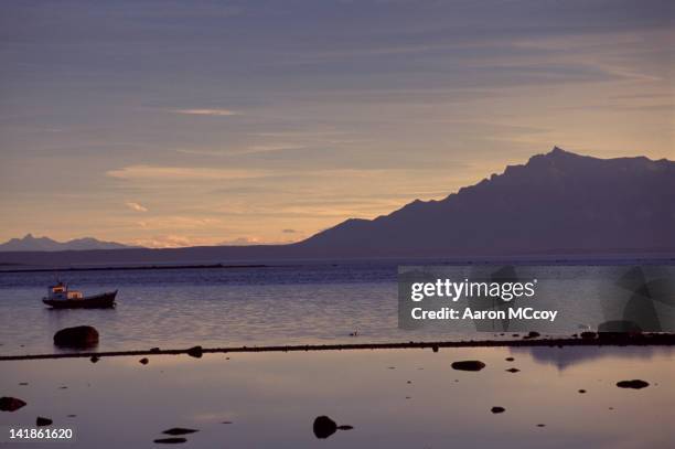 lone boat at sunset, puerto natales, chile, south america - puerto natales stock pictures, royalty-free photos & images