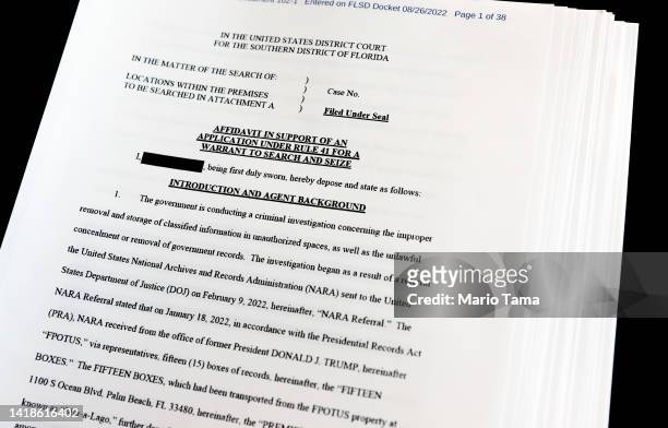 In this photo illustration, pages are viewed from the government’s released version of the F.B.I. Search warrant affidavit for former President...