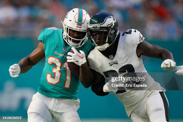 Raheem Mostert of the Miami Dolphins gets knocked out of bounds by Jaquiski Tartt of the Philadelphia Eagles during the first quarter of the...