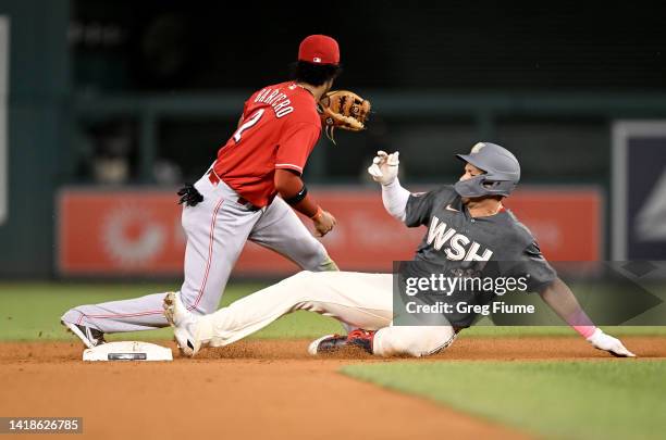 Joey Meneses of the Washington Nationals slides into second base for a double in the eighth inning ahead of the tag of Jose Barrero of the Cincinnati...