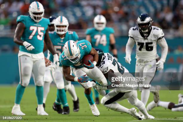Jaquiski Tartt of the Philadelphia Eagles tackles Myles Gaskin of the Miami Dolphins during the second quarter at Hard Rock Stadium on August 27,...