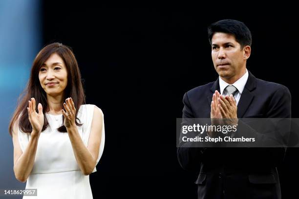 Yumiko Fukushima, wife of former Seattle Mariner Ichiro Suzuki, and interpreter Allen Turner clap during the Mariners Hall of Fame pregame ceremony...