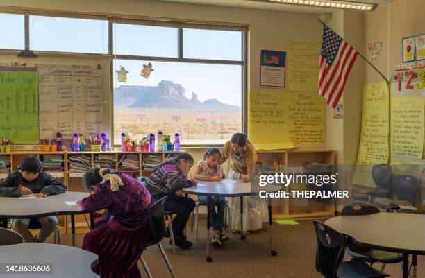young teacher checking her students work - navajo etniciteit stockfoto's en -beelden