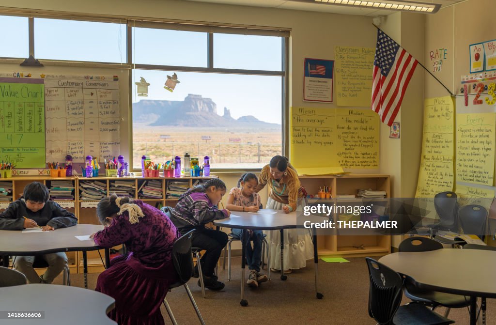 Young teacher checking her students work