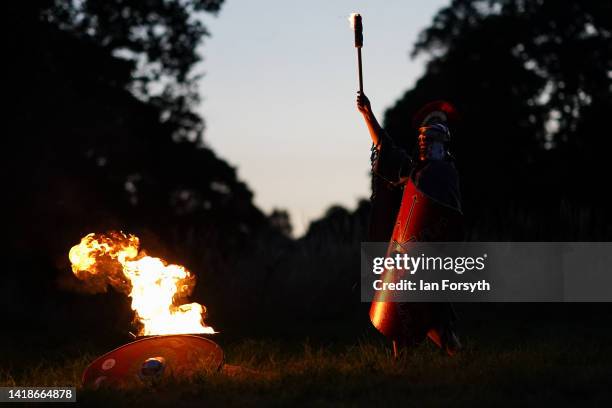 Roman soldier re-enactor holds a flaming torch as he takes part in a night attack battle at Chesters Roman Fort on August 27, 2022 in Hexham, United...