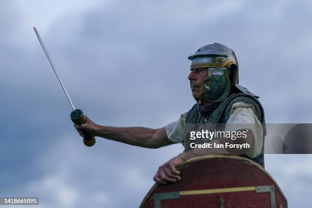 Roman soldier re-enactor shows his sword to the audience ahead of a Night Attack at Chesters Roman Fort on August 27, 2022 in Hexham, United Kingdom....
