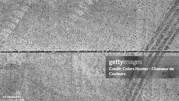close-up of a white line of a pedestrian crossing with a tire print in paris, france - asphalt stock-fotos und bilder