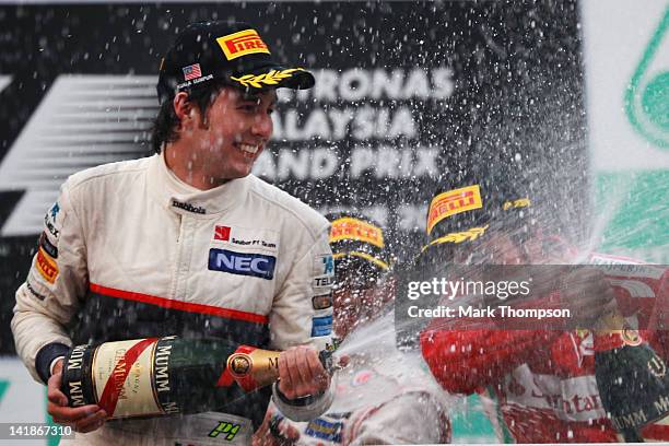 Sergio Perez of Mexico and Sauber F1 celebrates on the podium after finishing second during the Malaysian Formula One Grand Prix at the Sepang...