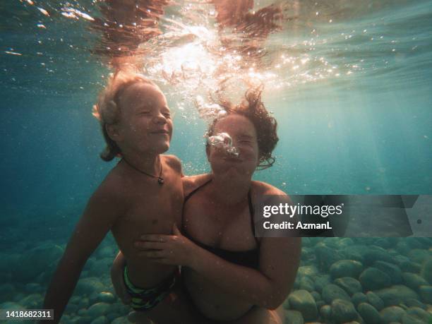 funny underwater shot of white single mother and son - funny face stock pictures, royalty-free photos & images