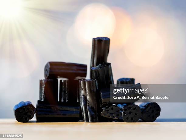 full frame of a  licorice candies illuminated by rays of sunlight. - hartbonbon stock-fotos und bilder