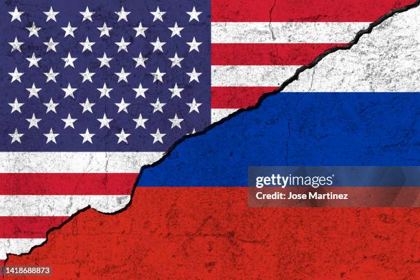 usa vs russia flags divided by a crack, concept of war, wall texture, division between countries - bandeira da rússia imagens e fotografias de stock