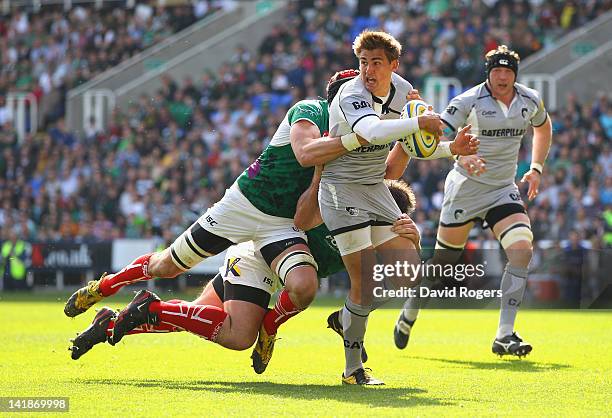 Toby Flood of Leicester breaks away from the tackle from Nick Kennedy and Faan Rautenbach during the Aviva Premiership match between London Irish and...