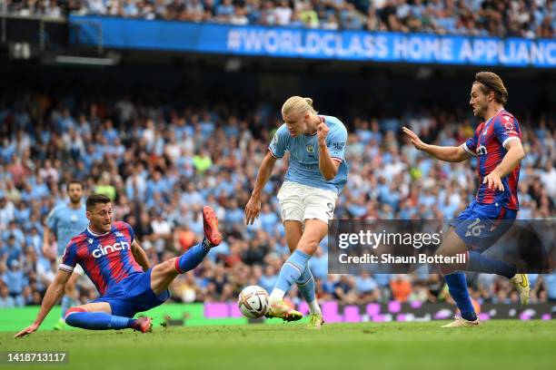 Erling Haaland of Manchester City shoots past Joel Ward and Joachim Andersen of Crystal Palace to claim a hat trick during the Premier League match...