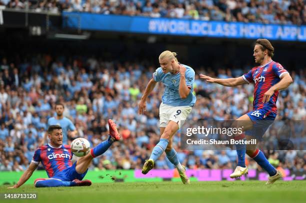 Erling Haaland of Manchester City shoots past Joel Ward and Joachim Andersen of Crystal Palace to claim a hat trick during the Premier League match...