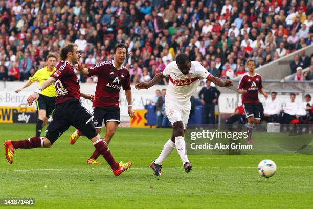 Cacau of Stuttgart scores his team's first goal against Dominic Maroh and Javier Pinola of Nuernberg during the Bundesliga match between VfB...