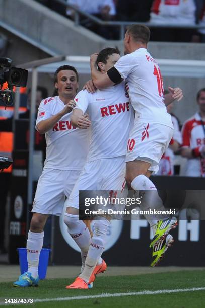 Milivoje Novakovic of Cologne celebrates with teammates Lukas Podolski and Slawomir Peszko after scoring his team's openig goal during the Bundesliga...