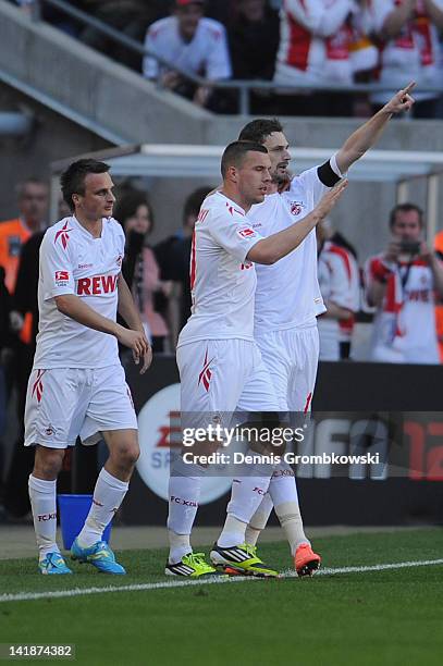 Milivoje Novakovic of Cologne celebrates with teammates Lukas Podolski and Slawomir Peszko after scoring his team's openig goal during the Bundesliga...