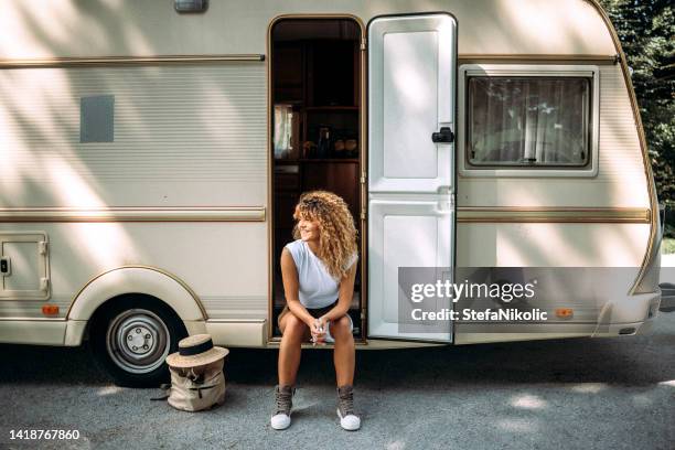 woman  sitting at the door of a campervan - trailer home stock pictures, royalty-free photos & images