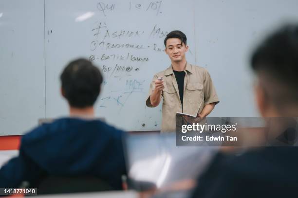 asian chinese college male student explain to the class with his answer written on whiteboard in classroom - chinese tutor study stock pictures, royalty-free photos & images