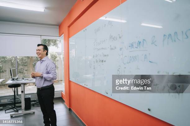 asiatisch-malaiischer dozent erklärt vor whiteboard im klassenzimmer und erklärt den schülern - mann vor pc stock-fotos und bilder