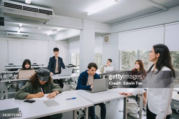 erwachsener student des asian college, der die frage des dozenten in der q & a-sitzung im klassenzimmer beantwortet - chinese tutor study stock-fotos und bilder