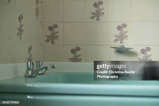 old, turquoise bathtub in vintage bathroom - bathtub stock pictures, royalty-free photos & images