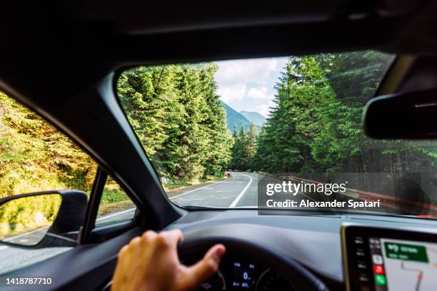 man driving on the mountain road surrounded by forest, personal perspective view - point of view driving stock-fotos und bilder
