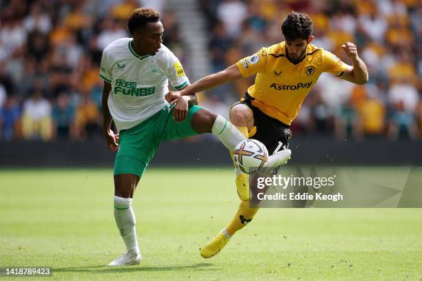 Joe Willock of Newcastle United and Goncalo Guedes of Wolverhampton Wanderers battle for the ball during the Premier League match between...