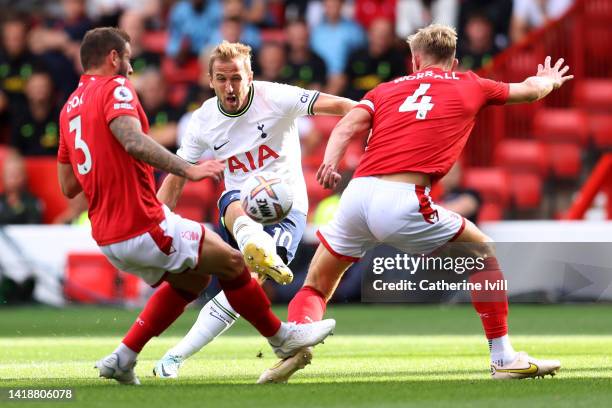 Harry Kane of Tottenham Hotspur shoots past Steve Cook and Joe Worrall of Nottingham Forest during the Premier League match between Nottingham Forest...