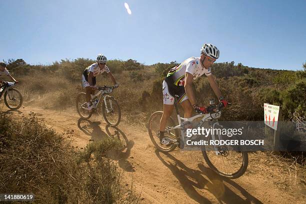 Reigning champions, Christof Sauser from Switzerland, and South African Burry Stander ride down a hill during the 27Km prologue stage at the start of...