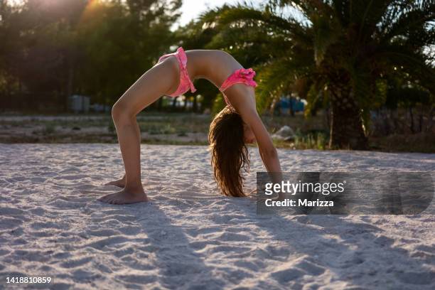 ビーチで新体操の練習中の若い運動少女 - young teen girl beach ストックフォトと画像
