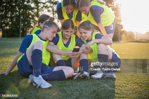 female soccer players relaxing after the game - teamsport stockfoto's en -beelden