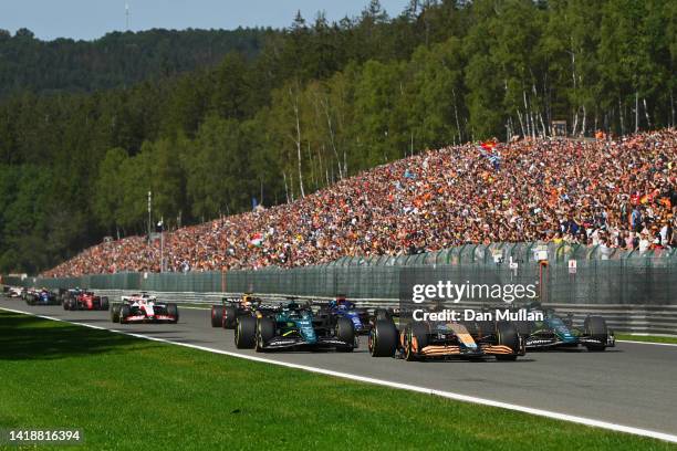 Daniel Ricciardo of Australia driving the McLaren MCL36 Mercedes leads Lance Stroll of Canada driving the Aston Martin AMR22 Mercedes and Sebastian...