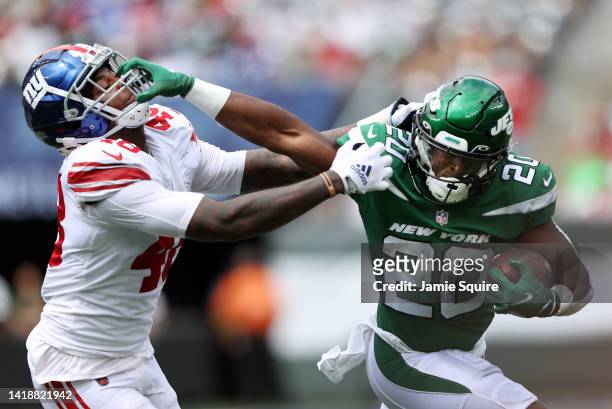 Running back Breece Hall of the New York Jets carries the ball as linebacker Tae Crowder of the New York Giants chases during the 1st half of the...