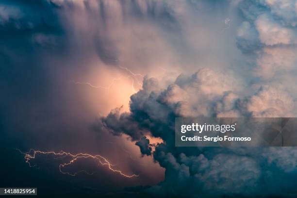 huge thunderstorm cloud with lightning activity - weather stock-fotos und bilder