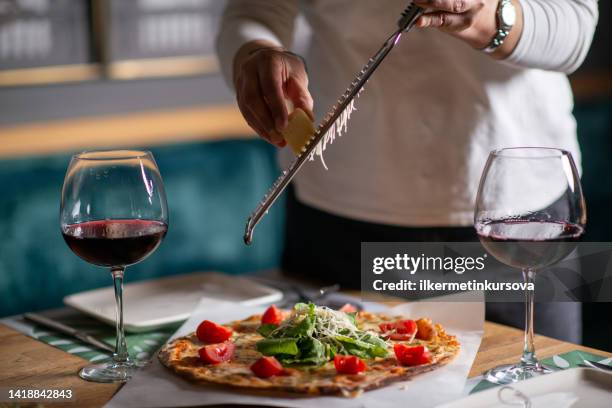 a chef hands grating cheese on a pizza - grater utensil stock pictures, royalty-free photos & images