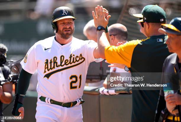 Stephen Vogt of the Oakland Athletics is congratulated by teammates and coaches after he scored against the New York Yankees in the bottom of the...