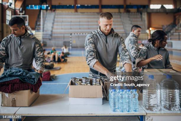 soldiers preparing donations for civilians - humanitarian aid stock pictures, royalty-free photos & images