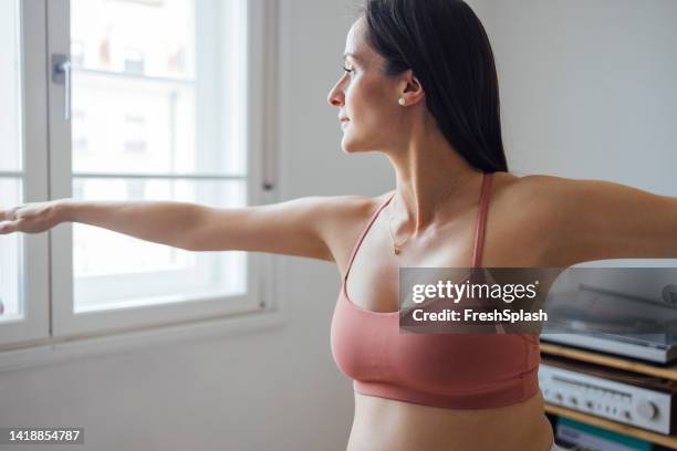 eine glückliche, schöne frau in sportkleidung, die gerne yoga macht - sport bh stock-fotos und bilder