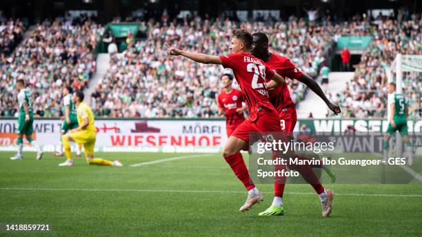 Jesper Lindstroem of Frankfurt celebrates with Randal Kolo Muani of Frankfurt after scoring his team's third goal during the Bundesliga match between...