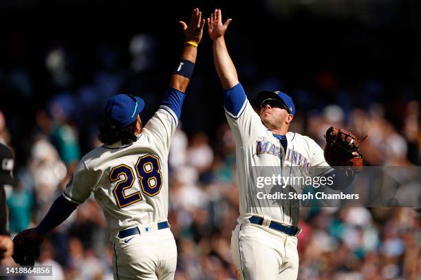 Eugenio Suarez and Ty France of the Seattle Mariners celebrate a 4-0 win against the Cleveland Guardians at T-Mobile Park on August 28, 2022 in...