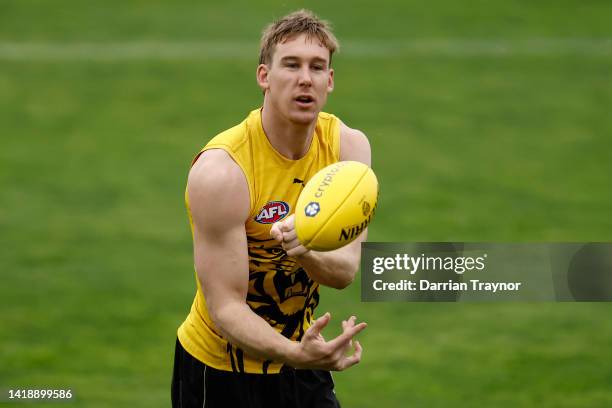 Tom J. Lynch of the Tigers handballs during a Richmond Tigers AFL training session at Punt Road Oval on August 29, 2022 in Melbourne, Australia.