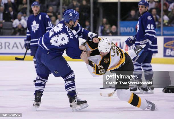 Tie Domi of the Toronto Maple Leafs fights with Dan LaCouture of the Boston Bruins in the first period of their NHL game on March 14, 2006 at Air...