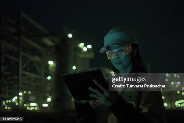 woman wearing mixed reality smart glasses at project petrochemical site night shift . - hands free apparaat stockfoto's en -beelden