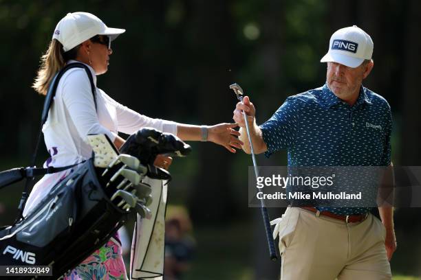 Jeff Maggert of the United States hands his putter to his caddie after finishing the 16h hole during the final round of The Ally Challenge at Warwick...