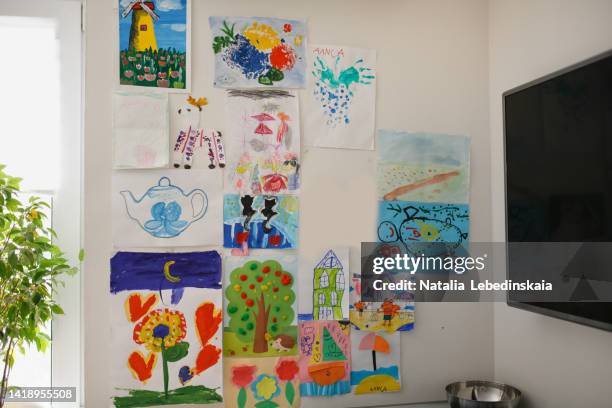 children's drawings hung in kitchen in house - dibujo producto artístico fotografías e imágenes de stock